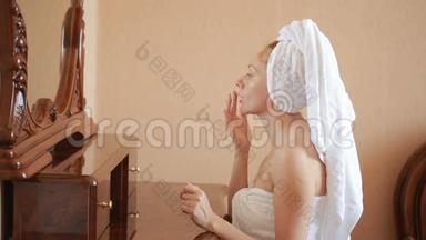 女人<strong>敷面膜</strong>保湿护肤霜在脸上照镜子。