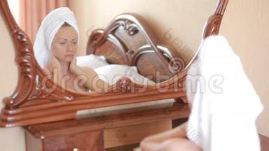 女人敷面膜保湿护肤霜在脸上照镜子。