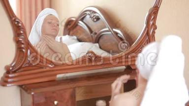 女人敷<strong>面膜保湿</strong>护肤霜在脸上照镜子。