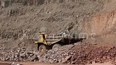一辆大型翻斗车在职业生涯中挖掘，一辆工业卡车在采石场挖货物，一辆黄色的大型翻斗车