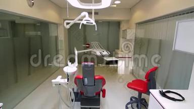 白色牙医办公室。 <strong>奢华</strong>的极简牙科诊所内部配有<strong>红</strong>色椅子和工具、玻璃墙上的牙科灯
