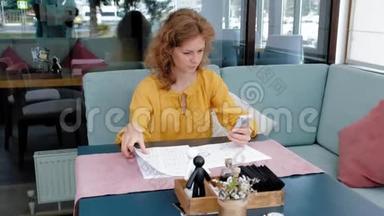 美丽的年轻女子在咖啡馆里浏览文件