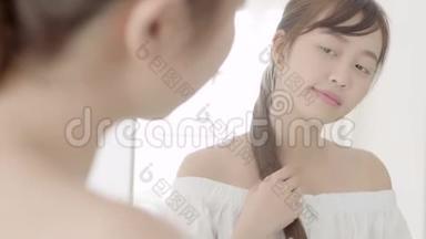 美丽的肖像年轻的亚洲女人微笑着看着镜子检查皮肤护理白种人在卧室健康