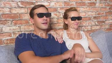 关上门。 一对年轻夫妇戴着3D眼镜，坐在客厅的沙发上，带着许多情绪，看<strong>电影</strong>。 4k