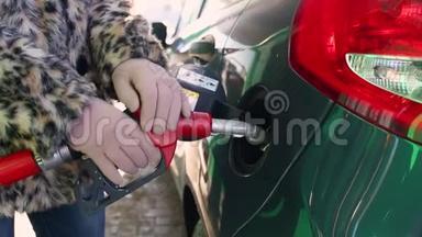 女人在冬天的加油站给她的车加油