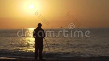 渔夫的剪影，日落时分在岩石上钓鱼