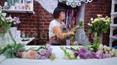 专业花艺师在花艺设计工作室挑选玫瑰花枝进行花束布置