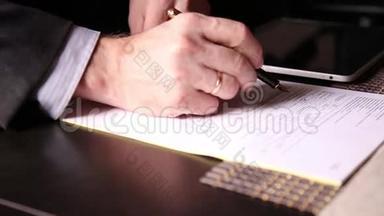 坐在办公桌前的商人签署了一份与个人电脑平板电脑比较的法案。 一个男人的特写和一个喷泉