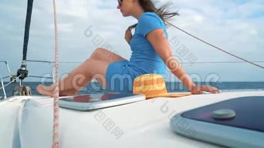 一位戴着黄色帽子的女士和一位穿着蓝色衣服的女孩在海洋的夏季靠近灯塔的游艇上休息