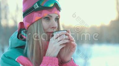 女人手里拿着热水瓶里的杯子，在雪白的树枝上喝茶