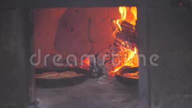 烤箱里烤的小比萨饼着火了。 慢动作视频。 厨师在明火上准备糕点。 烘焙