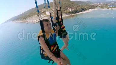 滑翔伞和滑翔伞的海洋生活方式。 男人和男孩正在海上乘降落伞飞行。 极限运动