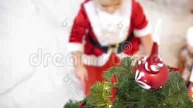 宝宝和孕妈在圣诞树上挂红球玩具。 快乐的童年概念。 孩子和母亲用