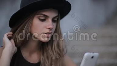 戴着黑帽子的漂亮女孩正在智能<strong>手机</strong>上<strong>输入</strong>一条信息