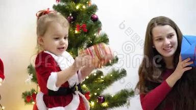 宝宝和<strong>孕妈</strong>在圣诞树上挂红球玩具。 快乐的童年概念。 孩子和母亲用