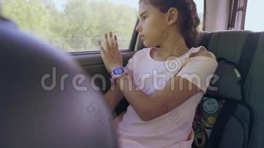 伤心的女孩无聊地坐在车里后座旅行。 运动小女孩在车里无聊。 概念长途旅行