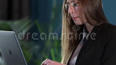 自信的女商人在她现代蓝色的现代办公室里使用笔记本电脑。时尚美女做