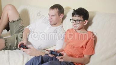 父亲和儿子在家里的沙发上玩电子游戏
