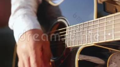 人手弹吉他.. 吉他手触摸吉他弦。 近距离射击。