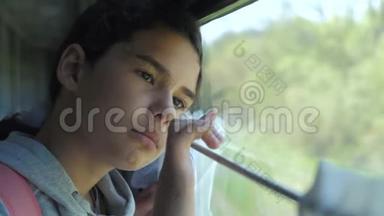 悲伤的女孩生活方式看着火车窗外。 旅游运输铁路概念。 十几岁的女孩错过了在