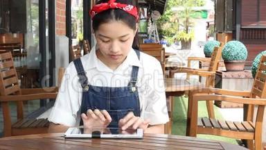泰国学生青少年漂亮女孩打字平板电脑。