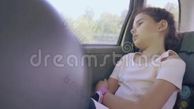 伤心的女孩无聊地坐在车里后座<strong>旅行</strong>。 小女孩在车里无聊的动作。 概念<strong>长途旅行</strong>