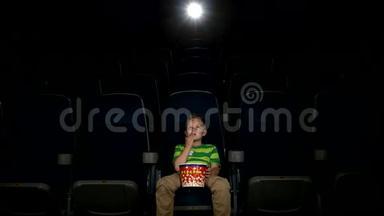 微笑的小男孩在电影院看电影