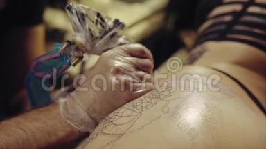 手套上纹身艺术家手的特写，纹身图案在身体宏观上