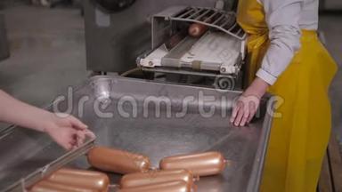 生产香肠。 工人在一家肉类加工厂操作肉类加工设备。