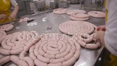 生产香肠。 工人在一家肉类加工厂操作肉类加工设备。