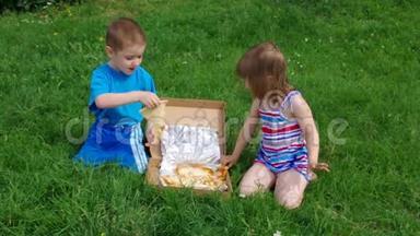 在<strong>草地上</strong>野餐.. 男孩和<strong>小女孩</strong>在<strong>草地上</strong>吃披萨。