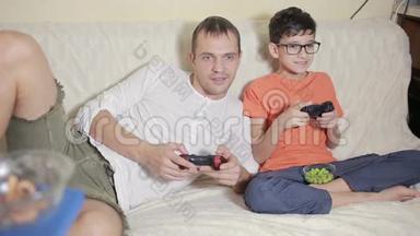 <strong>父亲和儿子在家里</strong>的沙发上玩电子游戏