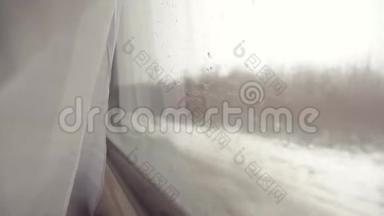 玻璃窗上的雨雪。 铁路概念火车旅行。 从火车的窗户可以看到美丽的景色