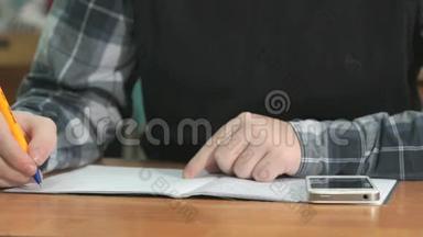 不知名的学生用钢笔在笔记本上写课文