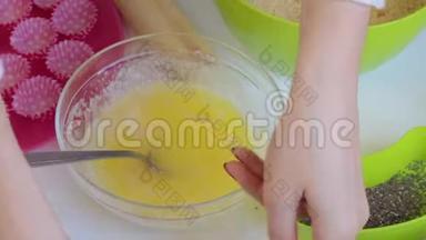 一个女人把可可粉滴入融化的黄油中混合。 为了做糖果。