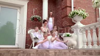 芭蕾舞学校的<strong>小</strong>女学生坐在学校的门廊上。 可爱的<strong>小女生</strong>在门廊梯子上的火车对面