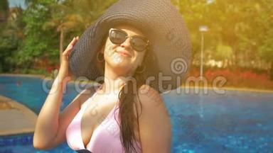 <strong>游泳</strong>池边戴蓝帽子的漂亮女孩。 <strong>夏日</strong>的阳光。 慢动作