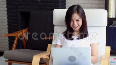 美丽的肖像亚洲年轻<strong>女子</strong>，微笑着<strong>坐在沙发上</strong>，在网上工作