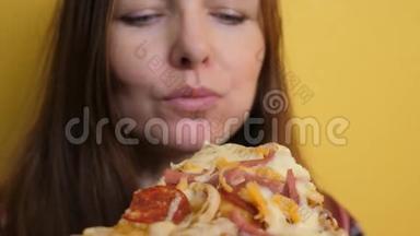 匹萨。 快乐的女孩吃一片披萨的概念。 饥饿的女人吃一片披萨。 慢动作视频。 披萨饼