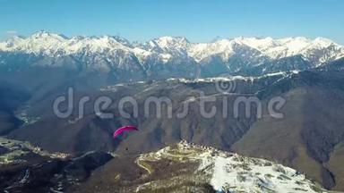 滑翔伞在滑雪场的山上飞过