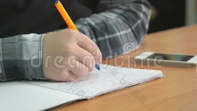 不知名的学生用钢笔在笔记本上写课文