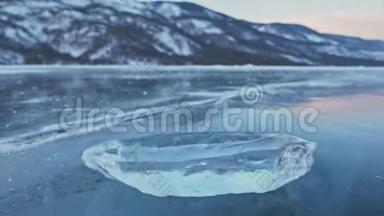 浮冰在令人惊叹的山景背景下在冰上旋转。 慢动作。 相机在移动