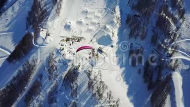 滑翔伞在滑雪场的山上飞过