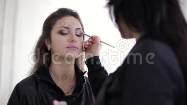 化妆师用眼影刷眼.