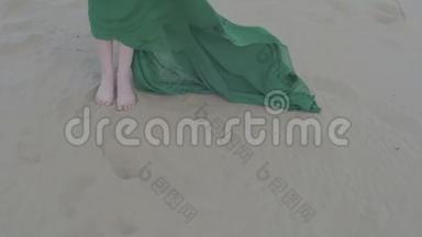穿绿色衣服的美女站在沙丘上