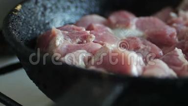 在煎锅里煮肉的慢镜头。 人类正在用特纳搅拌它。