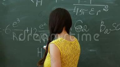 年轻大学生在数学课上在黑板或黑板上写字