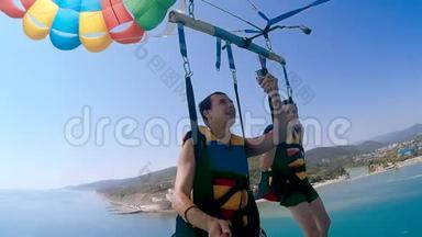 滑翔伞和海洋滑翔伞的生活方式。 男人和男孩正在海上乘降落伞飞行。 极限运动