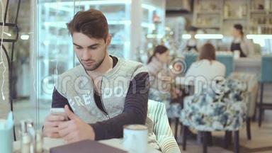 有智能手机的年轻人坐在咖啡馆里