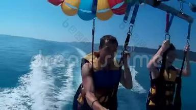 滑翔伞和滑翔伞的生活方式。 男人和男孩正在海上乘降落伞飞行。 海上极限运动